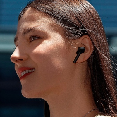 Auricular intra-auricular preto usado por mulher com cabelo castanho escuro