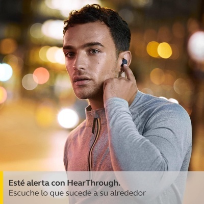 Homem com auricular preto e cinzento numa rua à noite