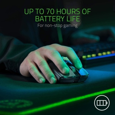 Mão usando rato de computador preto com texto sobre bateria e teclado retroiluminado