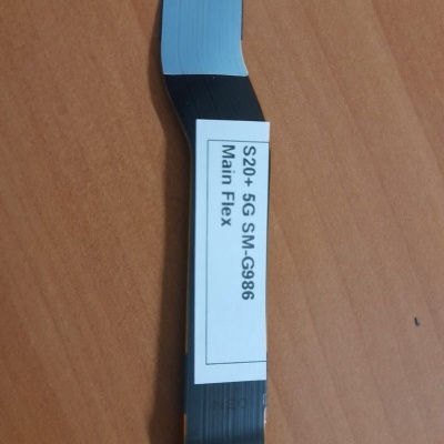 Cabo flexível preto com conectores dourados e etiqueta branca sobre superfície de madeira clara