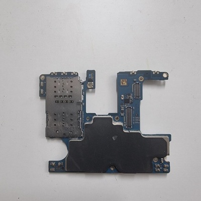 Placa de circuito impresso azul com componentes eletrónicos e cobertura metálica perfurada