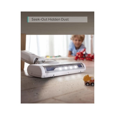 aspirador branco LED no chão de madeira com brinquedo de caminhão e criança ao fundo