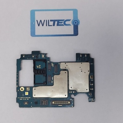 Placa eletrónica azul com componentes metálicos e chips colocada sobre papel com logo WILTEC