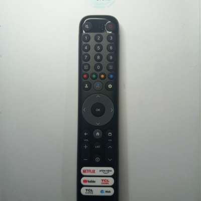 Comando remoto preto com botões coloridos e etiquetas de serviços de streaming