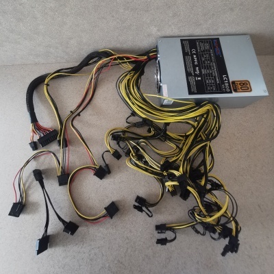Fonte de alimentação de computador com cabos pretos, amarelos e vermelhos sobre fundo claro