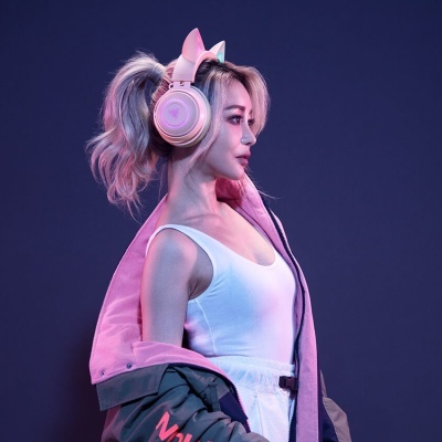 Mulher com auscultadores com orelhas de gato, camisola branca e casaco cinzento com interior rosa