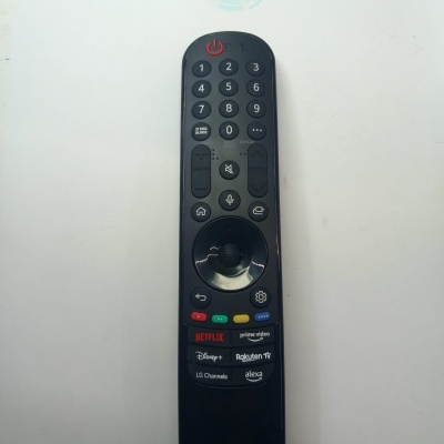 Comando remoto preto LG com botões para várias apps de streaming sobre fundo branco.