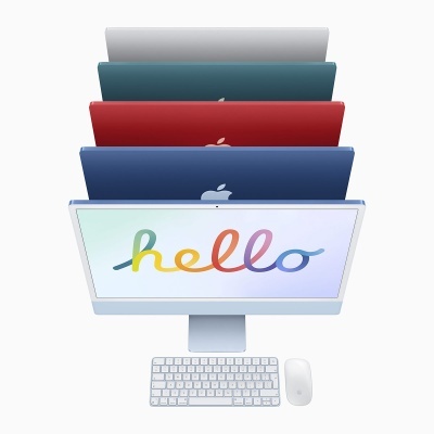 Computador Apple iMac com teclado, rato e capas coloridas atrás