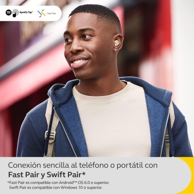 Homem com auscultadores brancos em rua urbana, casaco azul e mochila bege