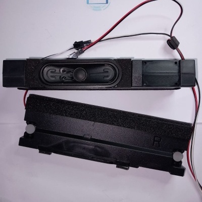 Alto-falantes finos pretos com cabos vermelhos e pretos e espuma sobre fundo branco