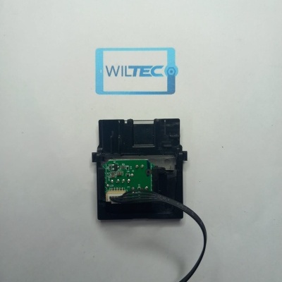 Peça eletrónica verde com cabo preto e estrutura plástica preta sobre fundo branco com logo WILTEC