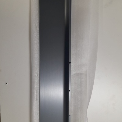 Painel metálico cinza escuro sobre fundo branco com etiqueta amarela