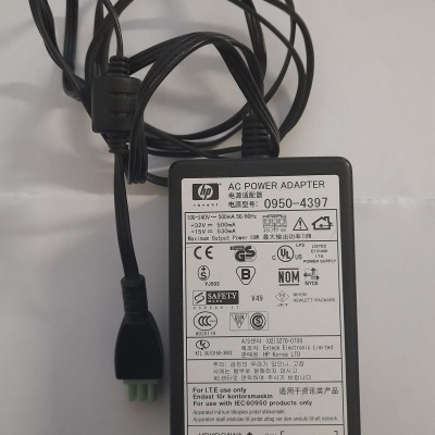 Adaptador de energia HP preto com etiqueta técnica em fundo branco