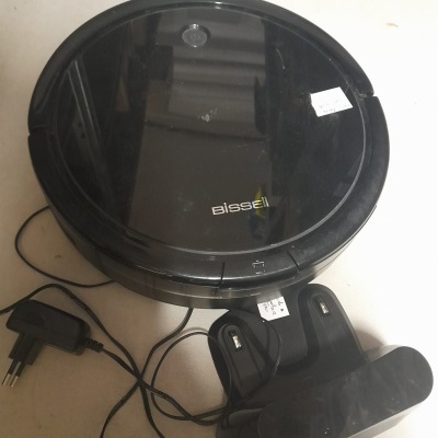 Robô aspirador de pó Bissell preto com carregador e base de carregamento