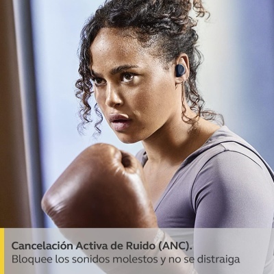 Mulher a usar auriculares sem fios pretos enquanto pratica boxe com luvas castanhas