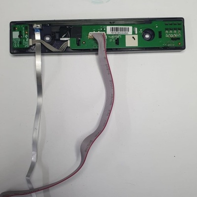 Placa eletrónica verde com cabo plano sobre superfície branca