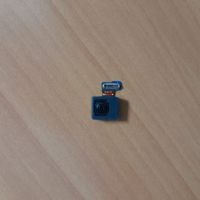 Pequena câmara eletrónica preta com flexível azul sobre madeira clara