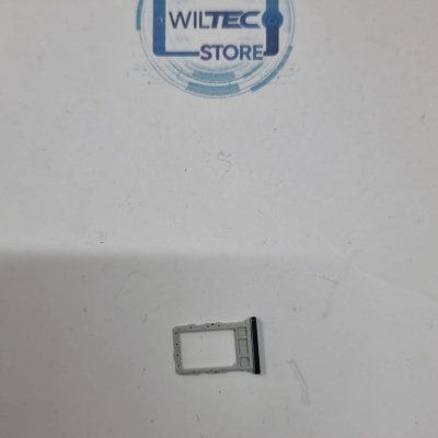 Suporte de cartão SIM metálico prateado com uma parte preta numa superfície branca com selo WILTEC STORE.