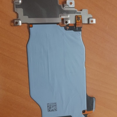 Componente eletrónico cinzento e azul claro sobre mesa de madeira.