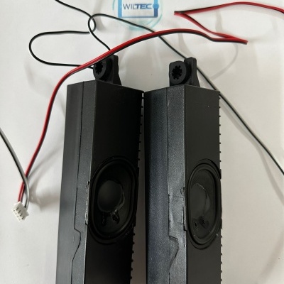 Par de colunas pretas com cabos eléctricos numa superfície branca