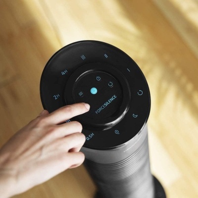 Controlador circular preto com texto FORESCIENCE e ícones, dedo a tocar no dispositivo cilíndrico.