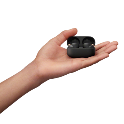 Auriculares sem fios pretos no estojo preto na mão.