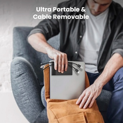 Pessoa a colocar portátil cinzento com cabo removível numa mochila castanha