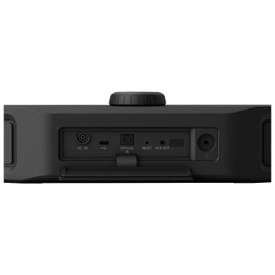 Parte traseira de dispositivo de áudio preto com várias entradas e botão rotativo.