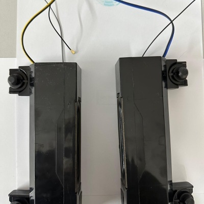 Dois alto-falantes pretos com fios coloridos sobre papel branco com logo WILTEC