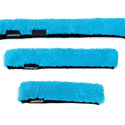 três almofadas felpudas azuis com etiquetas pretas e texto branco