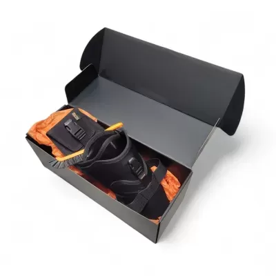 Caixa preta aberta com arnês preto e item laranja ao lado