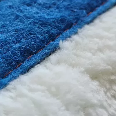 Tecido azul felpudo com costura vermelha junto a tecido branco macio e espesso