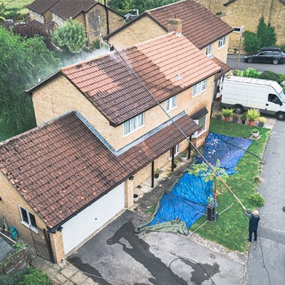 Casa geminada com telhado vermelhos e relvado com lonas azuis