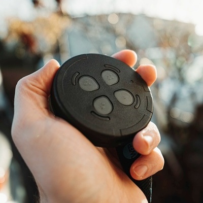 Comando remoto preto com quatro botões na mão