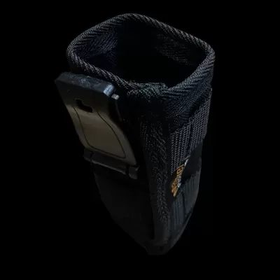 Bolsa preta em tecido com fivela plástica sobre fundo negro