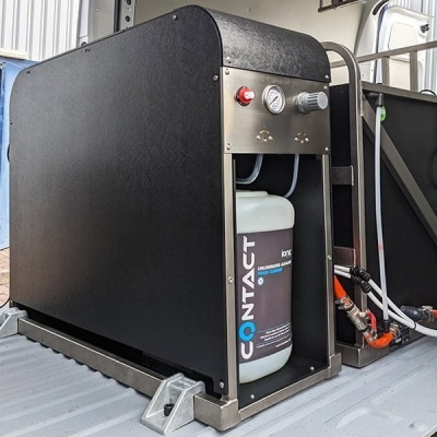 Equipamento industrial metálico preto com medidor de pressão e depósito branco rotulado 'CONTACT'