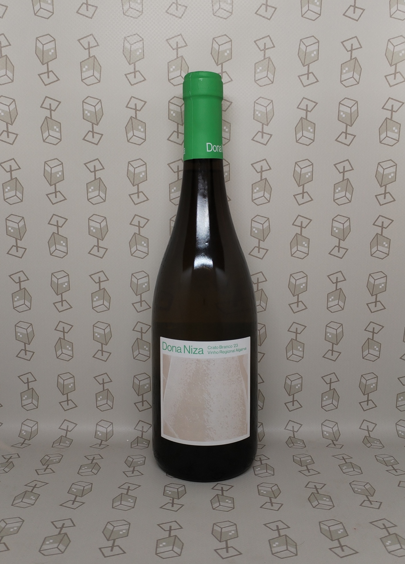 Garrafa de vinho Dona Niza com tampa verde sobre papel de parede com padrão geométrico.