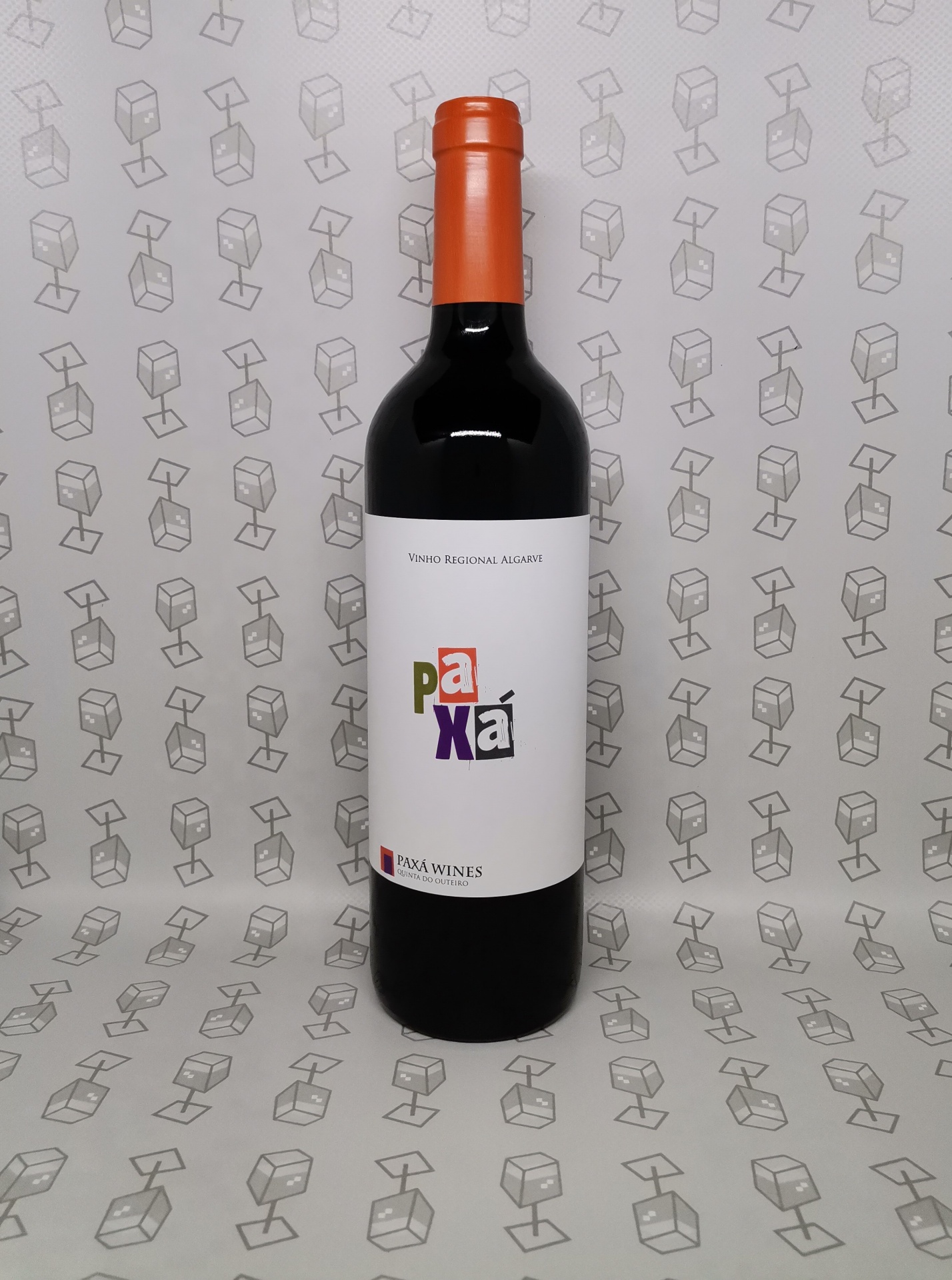 Garrafa de vinho tinto com rótulo branco e tampa laranja sobre fundo padrão com cubos cinza