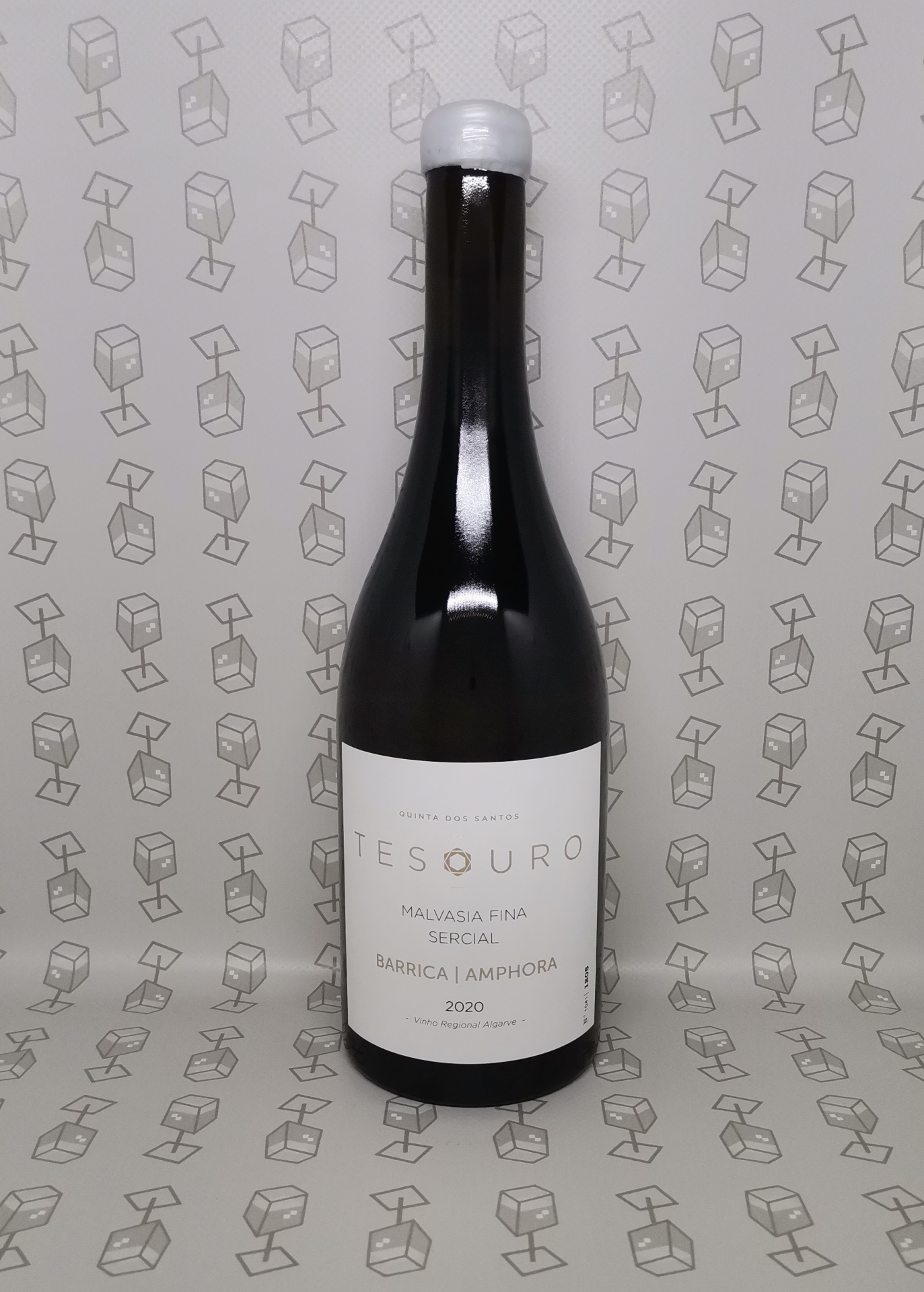 Garrafa de vidro escuro com rótulo branco e tampa branca em fundo e superfície com padrão de caixas.