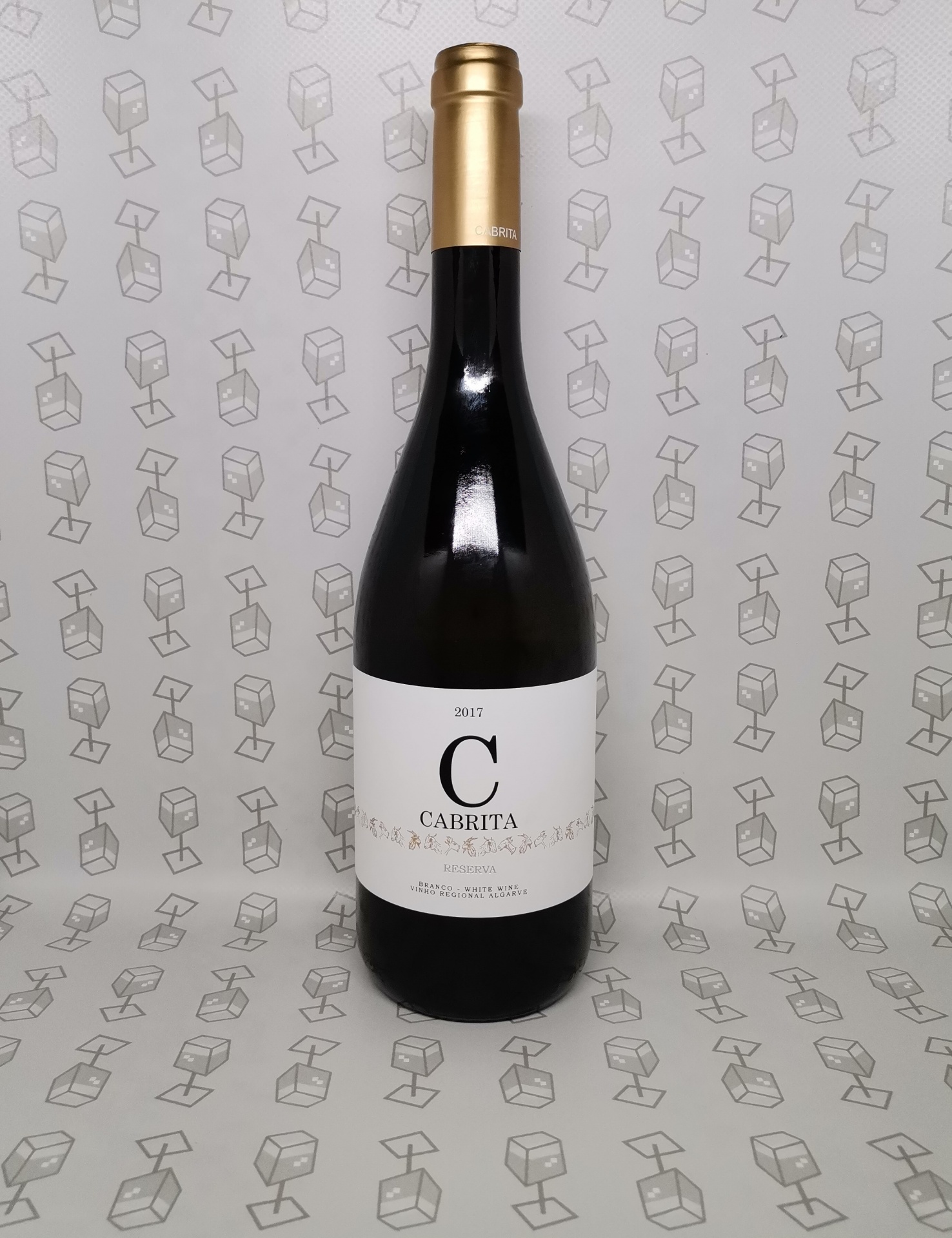 Garrafa de vinho tinto com rótulo branco e tampa dourada sobre fundo com padrão de caixas desenhadas.