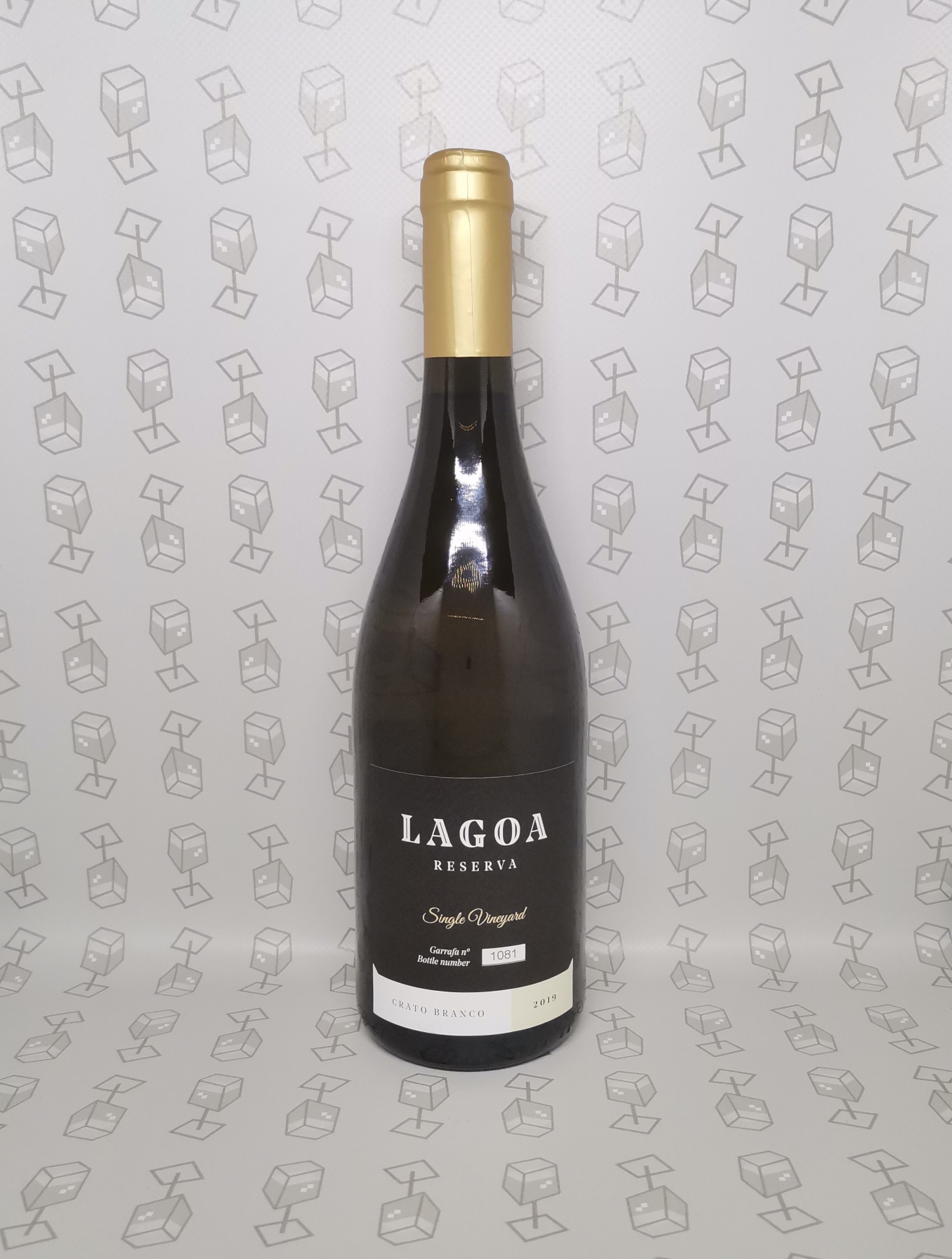 Garrafa de vinho LAGOA RESERVA com rótulo preto e dourado sobre fundo claro com padrão de caixas de vinho.