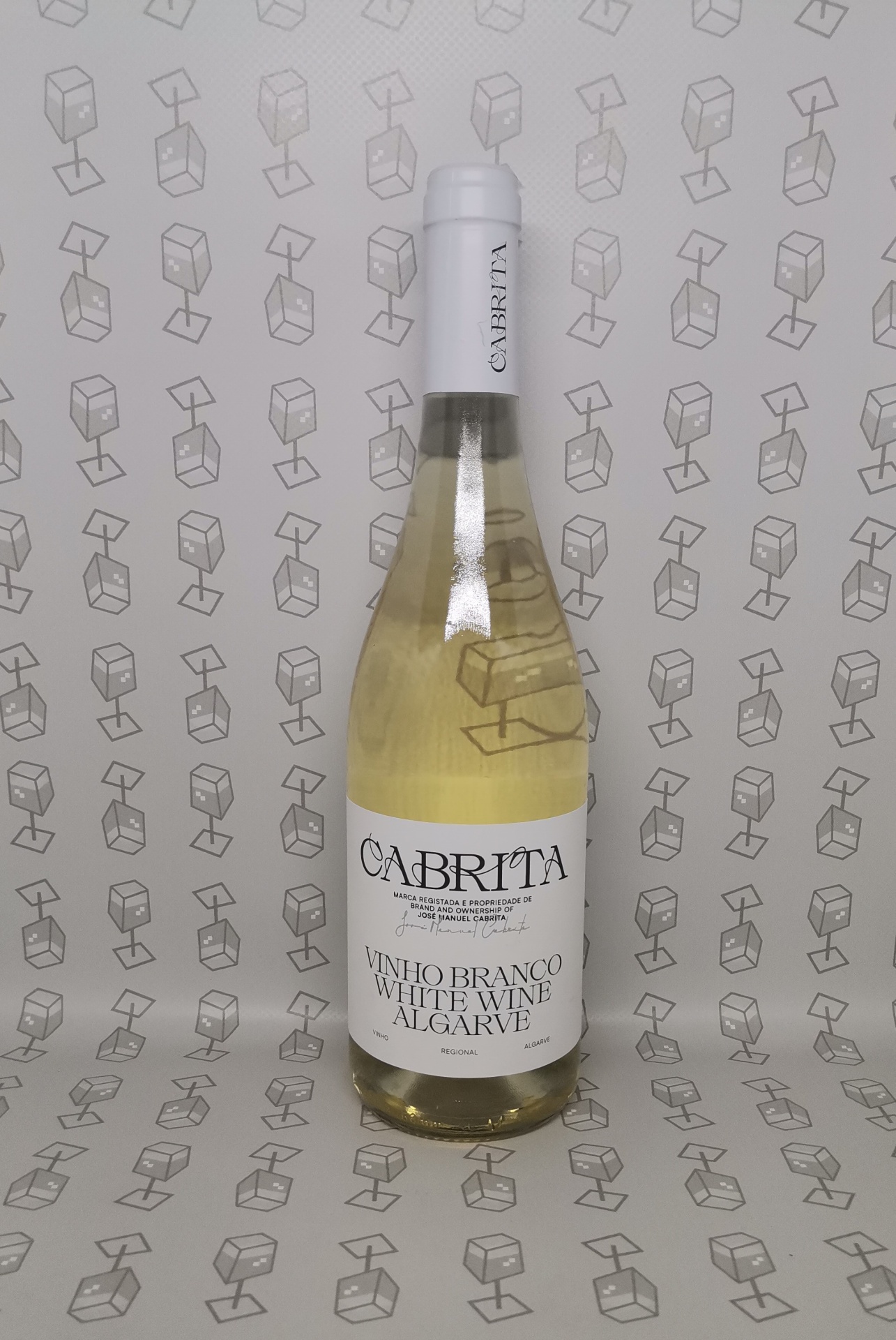 Garrafa de vinho branco CABRITA com rótulo e rolha brancos, em fundo com padrão de caixas de luz cinzentas