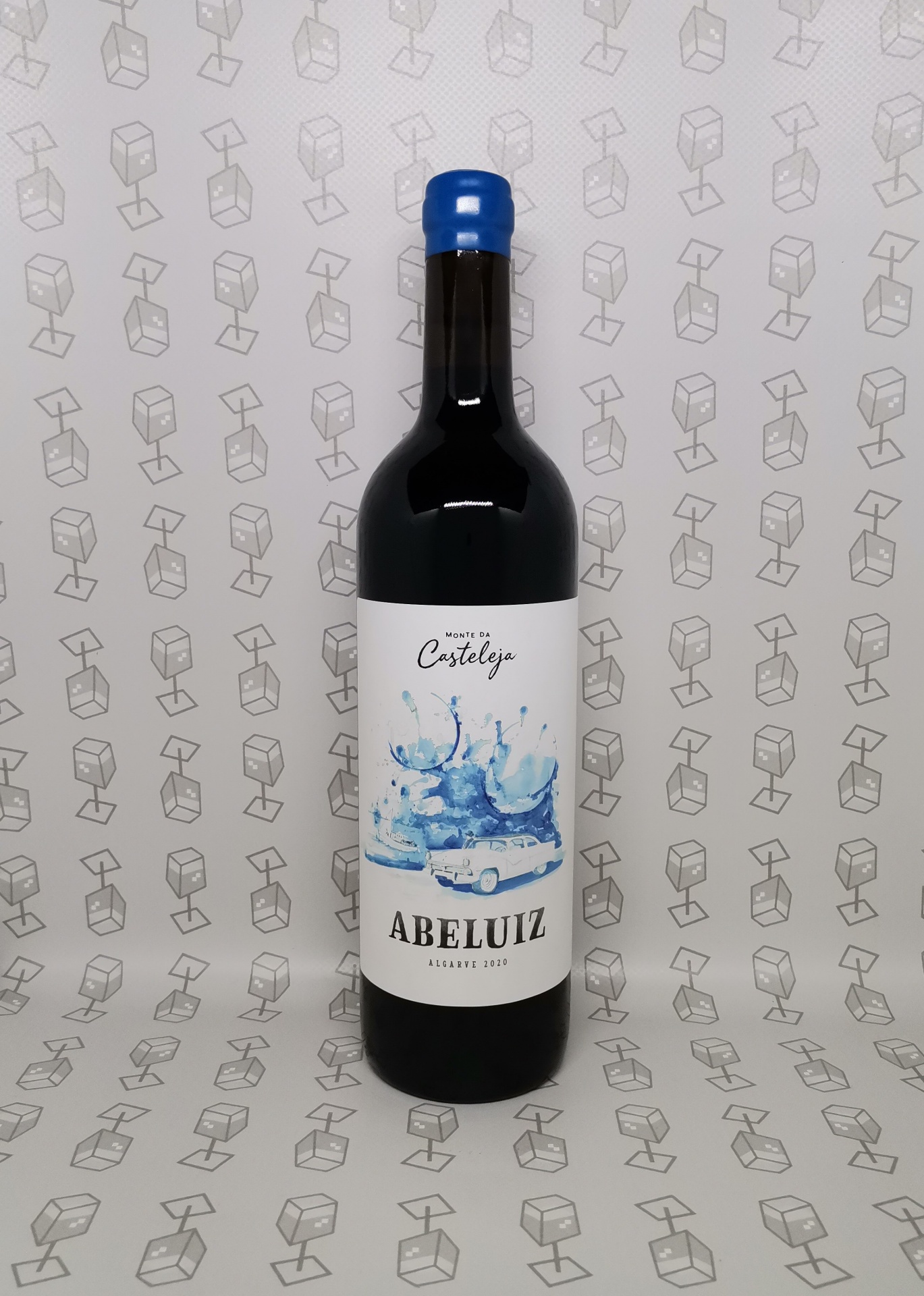 Garrafa escura de vinho com rolha azul e etiqueta branca com desenho azul e texto