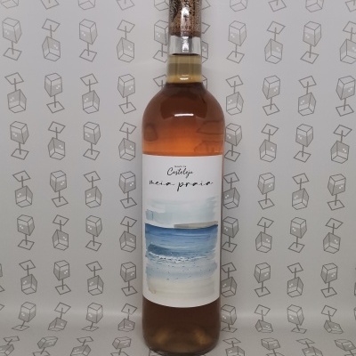 Garrafa de líquido âmbar com rótulo azul e branco e tampa de cortiça em fundo com padrão de caixas