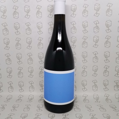 Garrafa de vidro escuro com rótulo azul sobre fundo branco com padrão de cadeiras cinza