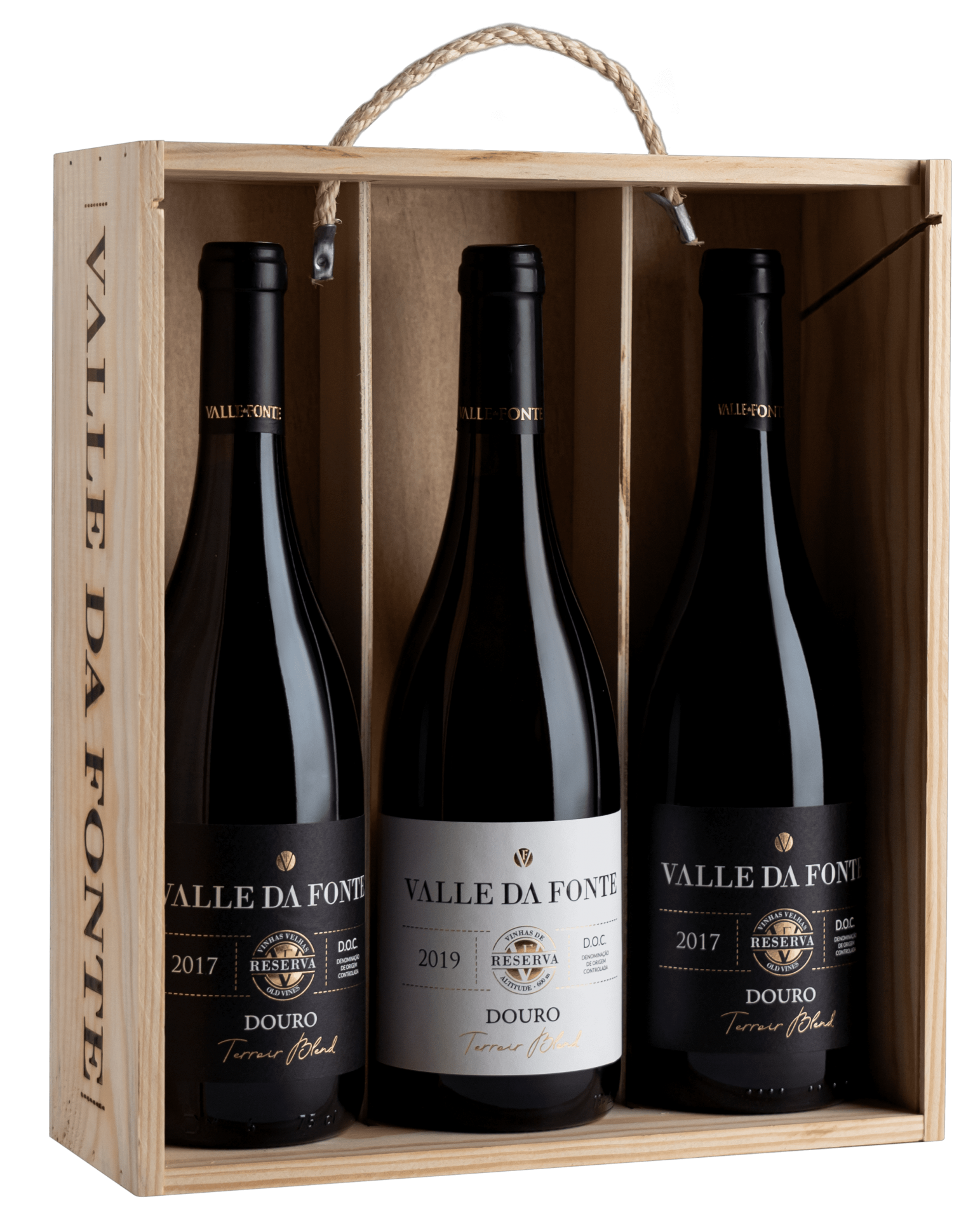 Caixa de madeira com três garrafas de vinho tinto Valle Da Fonte em fundo preto.
