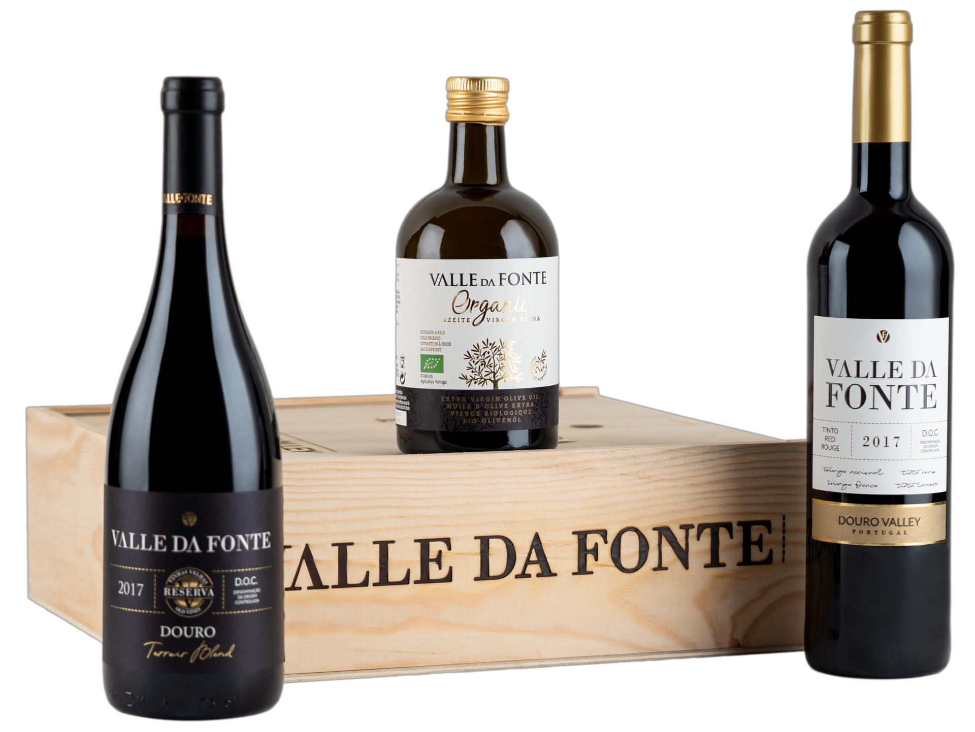 Três produtos Valle da Fonte: duas garrafas de vinho tinto e uma pequena garrafa de azeite à frente de uma caixa de madeira com texto.