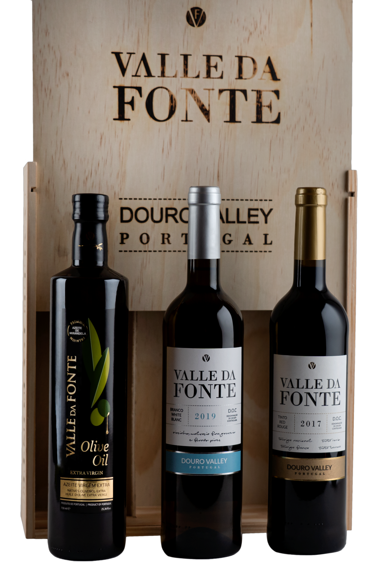 Três produtos Valle Da Fonte: azeite extra virgem e duas garrafas de vinho com rótulos azul e dourado em caixa de madeira.