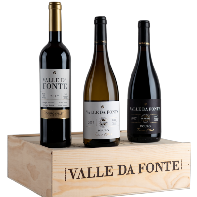 Três garrafas de vinho Valle da Fonte sobre caixa de madeira com nome da marca.