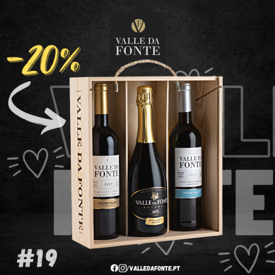 Caixa de madeira com três garrafas de vinho Valle da Fonte, duas tintas e uma espumante, sobre fundo preto com texto promocional